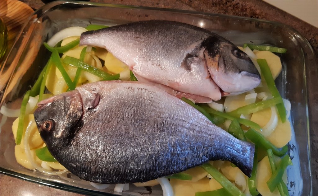 Receta de dorada al horno con patatas, pimiento y cebolla